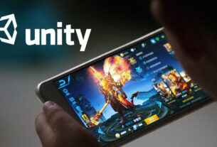 A person holding a smartphone playing a mobile game with the Unity logo displayed.